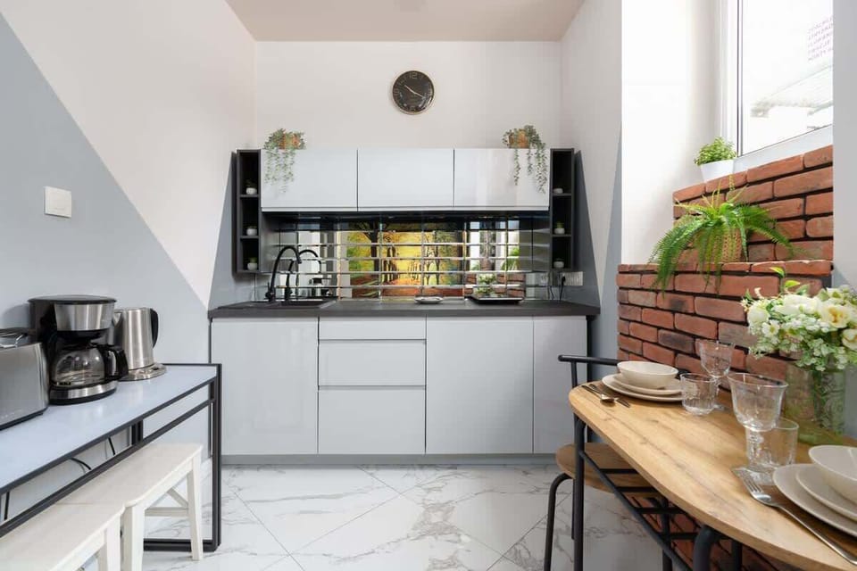 Functional kitchenette with sleek cabinets, modern appliances, and a charming combination of materials.

