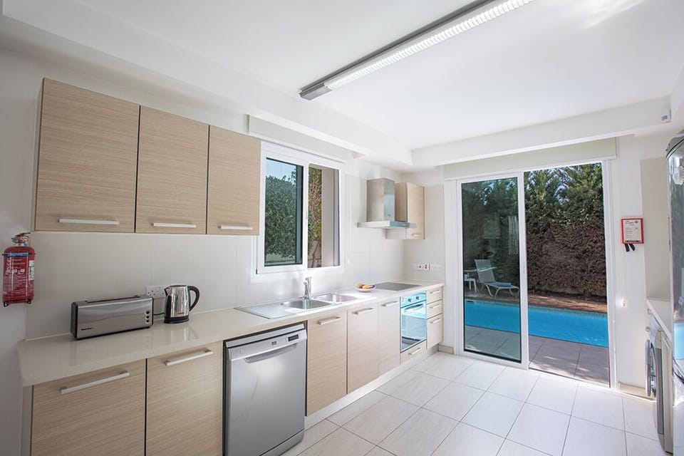 Fully Equipped modern kitchen with patio doors leading the garden and pool