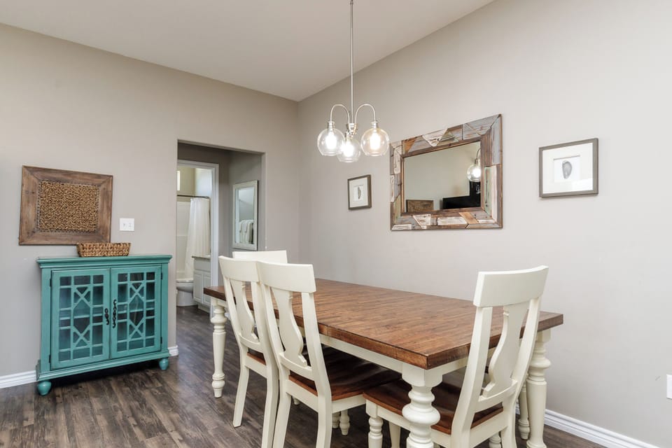 Share memorable meals at your rustic farmhouse dining table, where warm wood tones and coastal charm create the perfect gathering space.