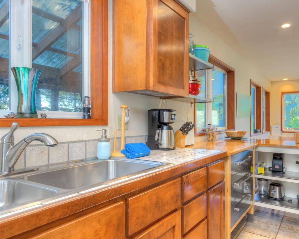 Fully equipped kitchen with access out to back deck with hot tub and outdoor dining area.