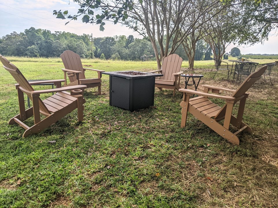 Propane fire pit + Adirondack chairs + picnic table and chairs overlooking farm