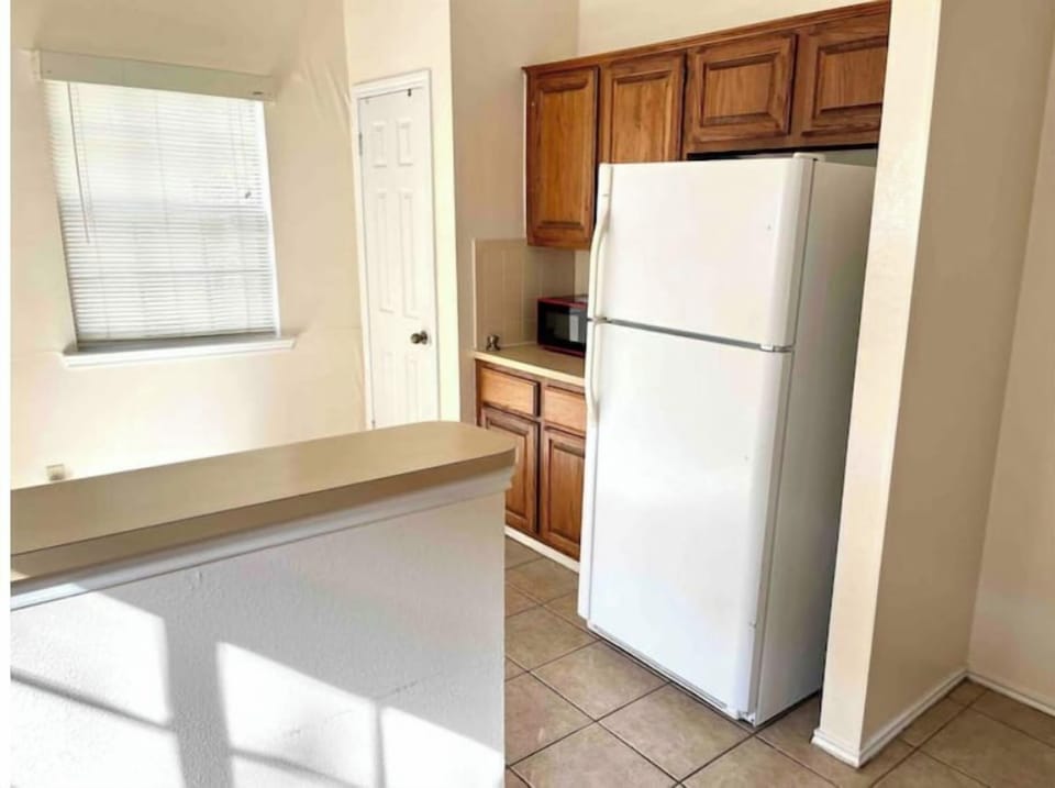Full sized refrigerator next to coffee bar