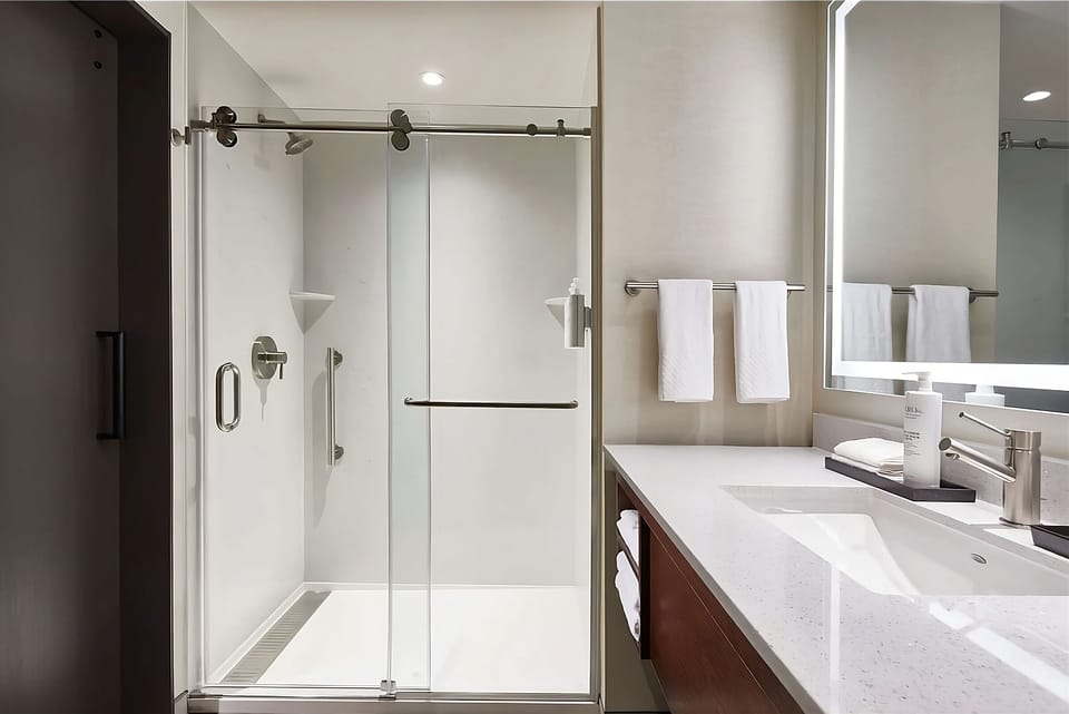 Refresh in a sleek walk-in shower with bright vanity.