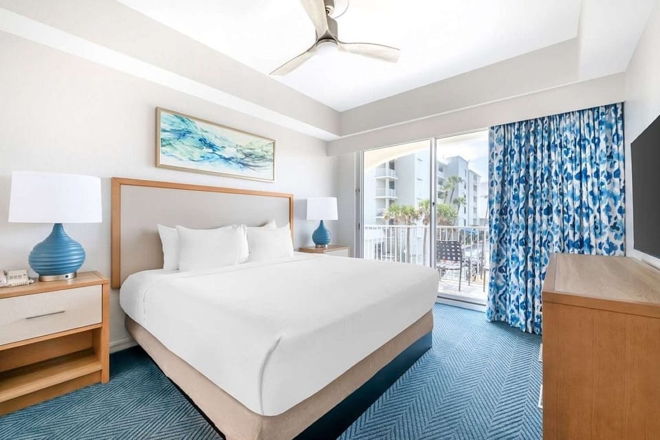 Primary Bedroom • Queen Bed, Media Console & Balcony Access