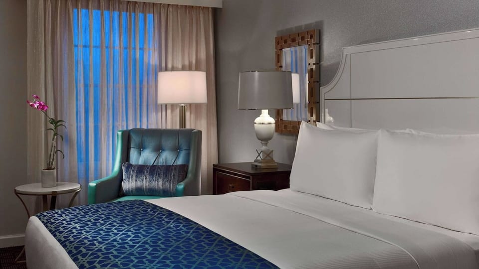 Sink into crisp sheets beside a cozy reading chair.