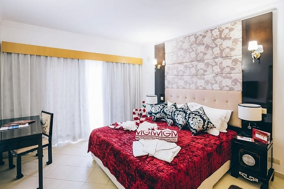 Sink into plush bedding with elegant headboard and soft lamps.