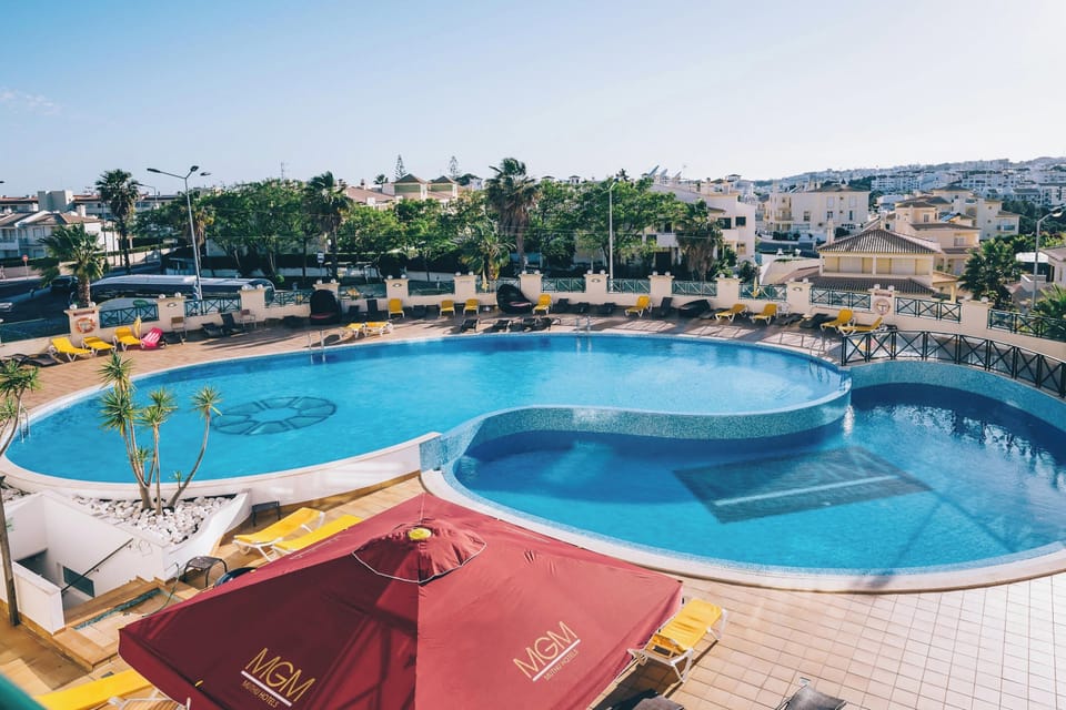 Dive into sunlit resort serenity with panoramic poolside views.