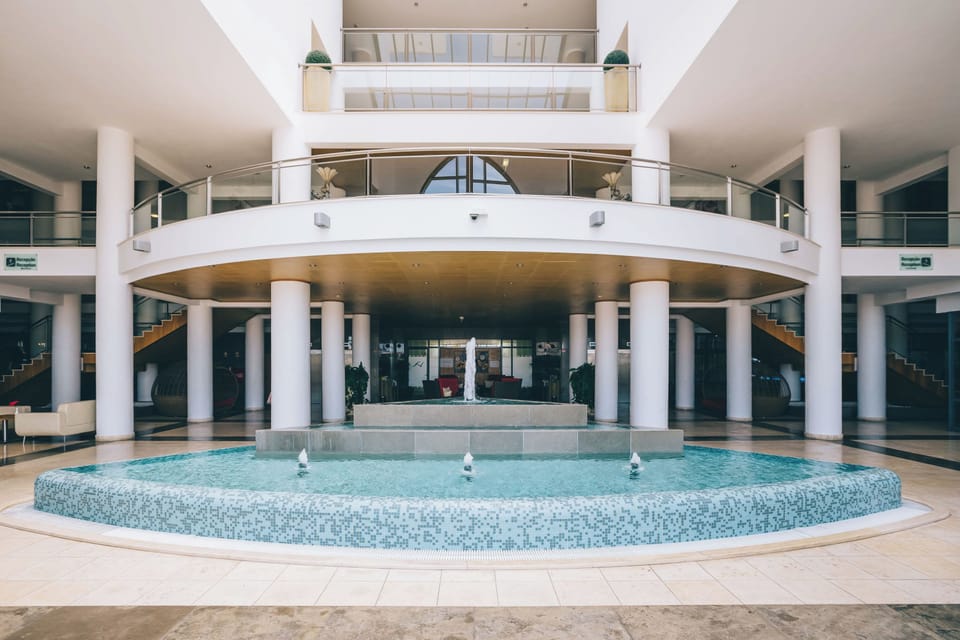 Unwind beside the tranquil lobby fountain under soaring arches.