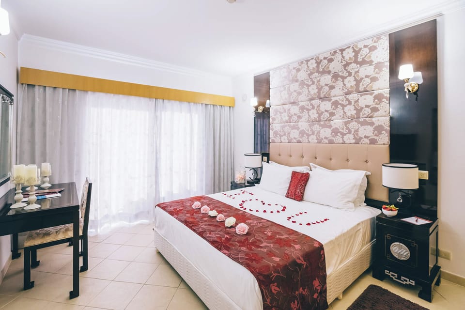 Wake up to daylight filtering through wide curtains by the bed.