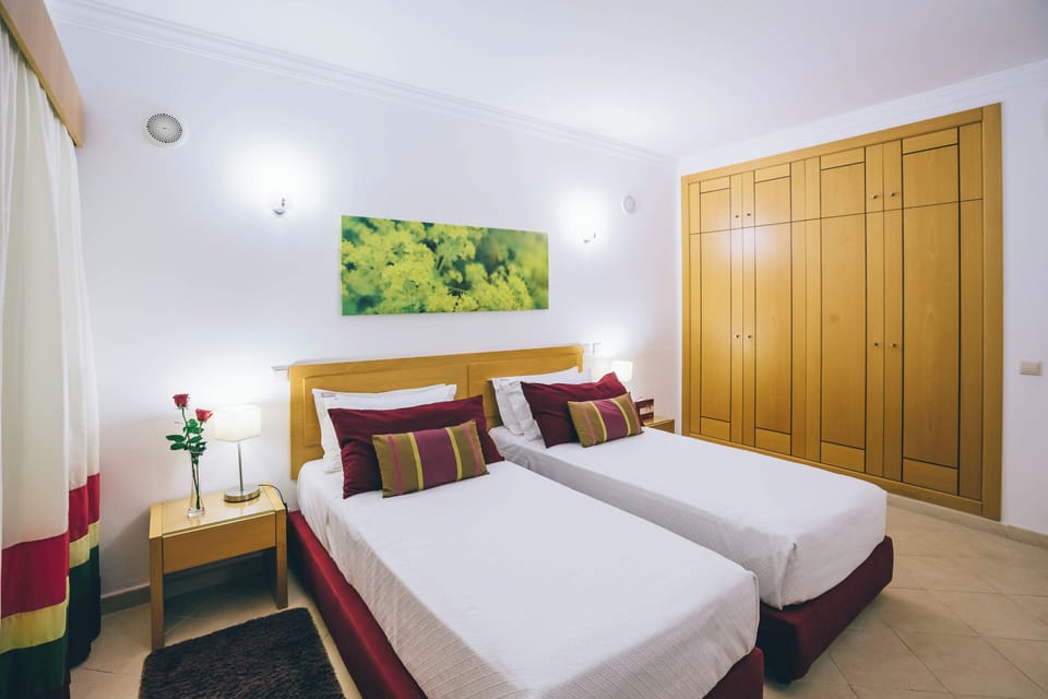 Drift off comfortably in twin beds with soft bedside lighting.