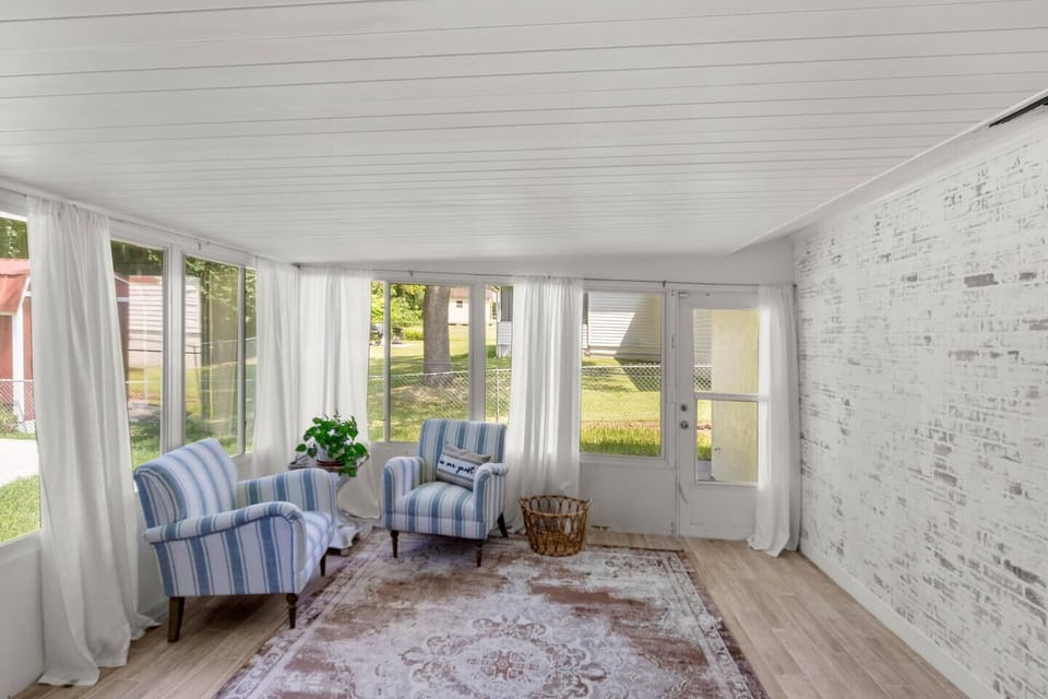 🌞 Inviting Sunroom with a View Cozy nook with comfy seating, soft natural light, and serene outdoor
