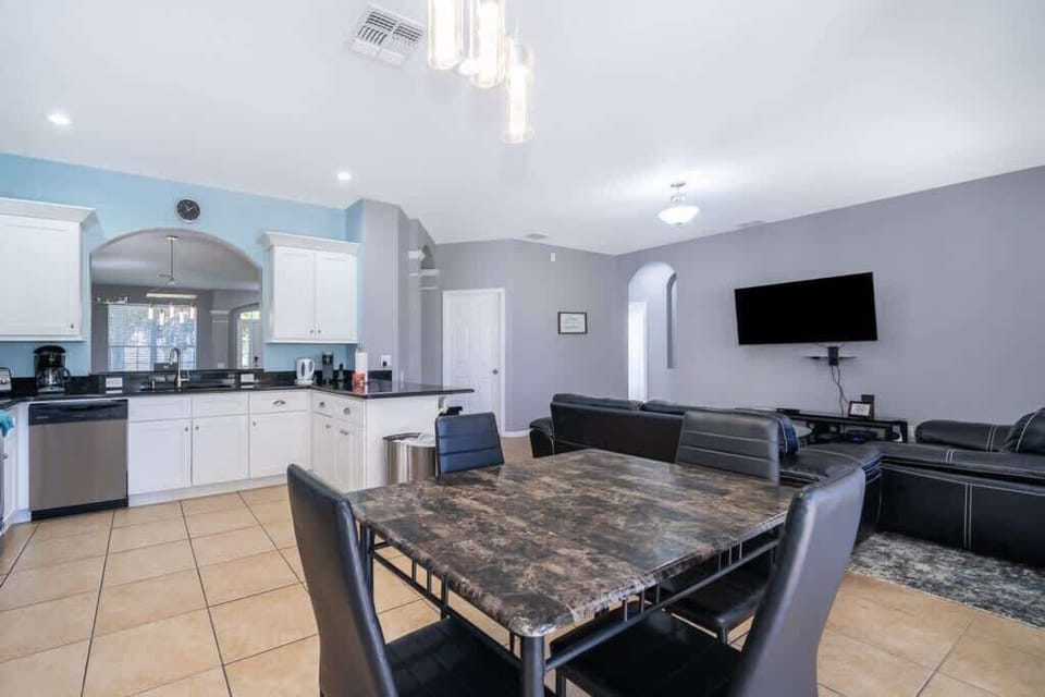 The dining area features a sleek and stylish table with four comfortable chairs, perfect for intimate meals or casual gatherings.