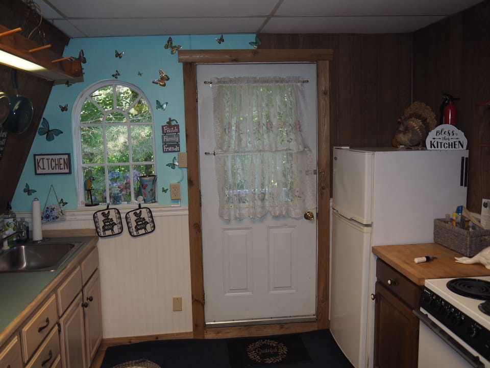 KITCHEN:  Full kitchen including sink, counter, cabinets, refrigerator, electric range and a good supply of cooking and dining utensils.