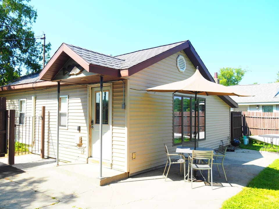 EXTERIOR:  The side and back of the house in summer.