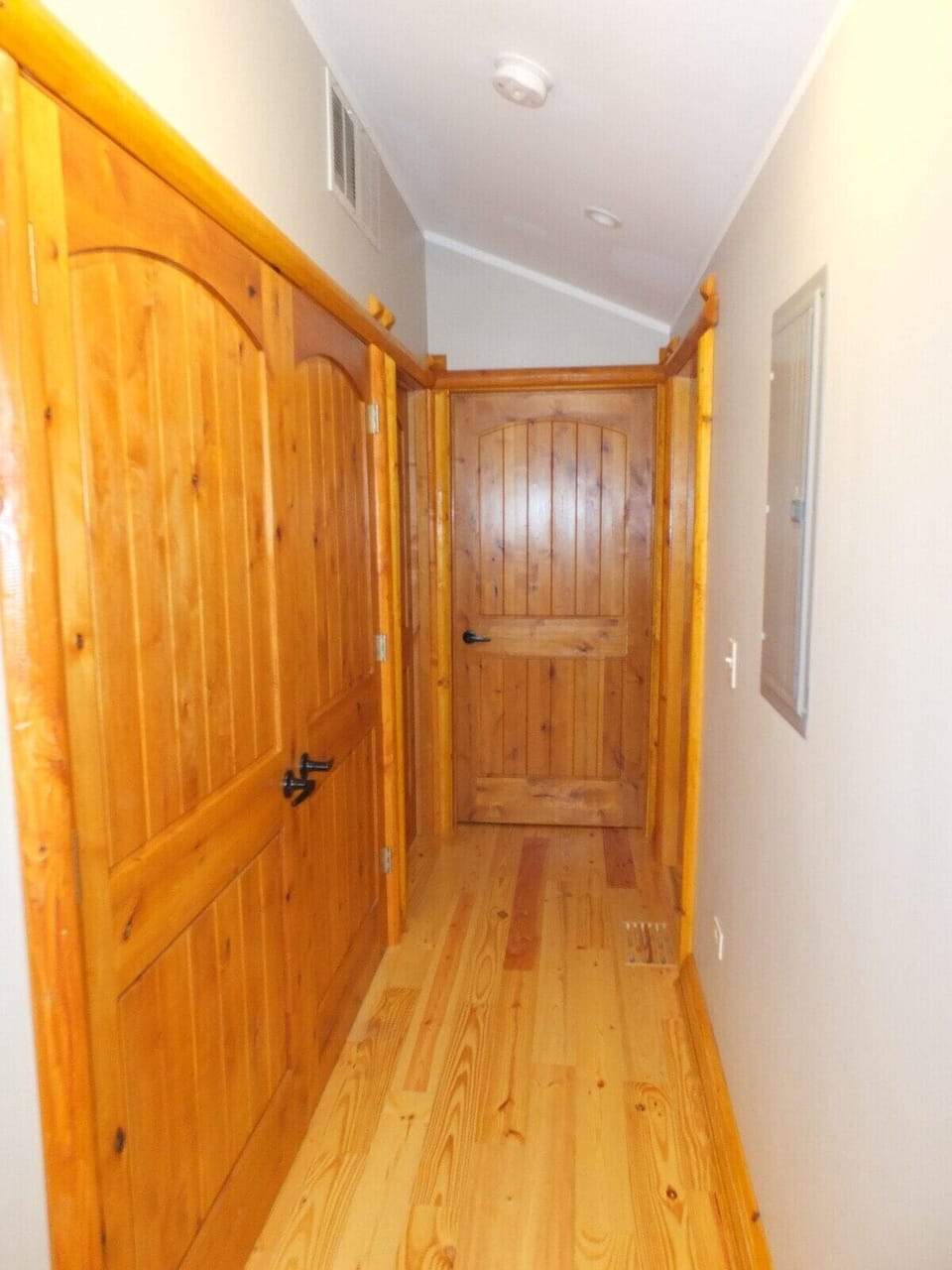 HALLWAY:  This hallway from the kitchen leads to each of the 3 bedrooms as well as the washer and dryer.  The washer and dryer are behind the double doors near the front of the photo.  The doors to each of the 3 bedrooms are at the end of the hall.