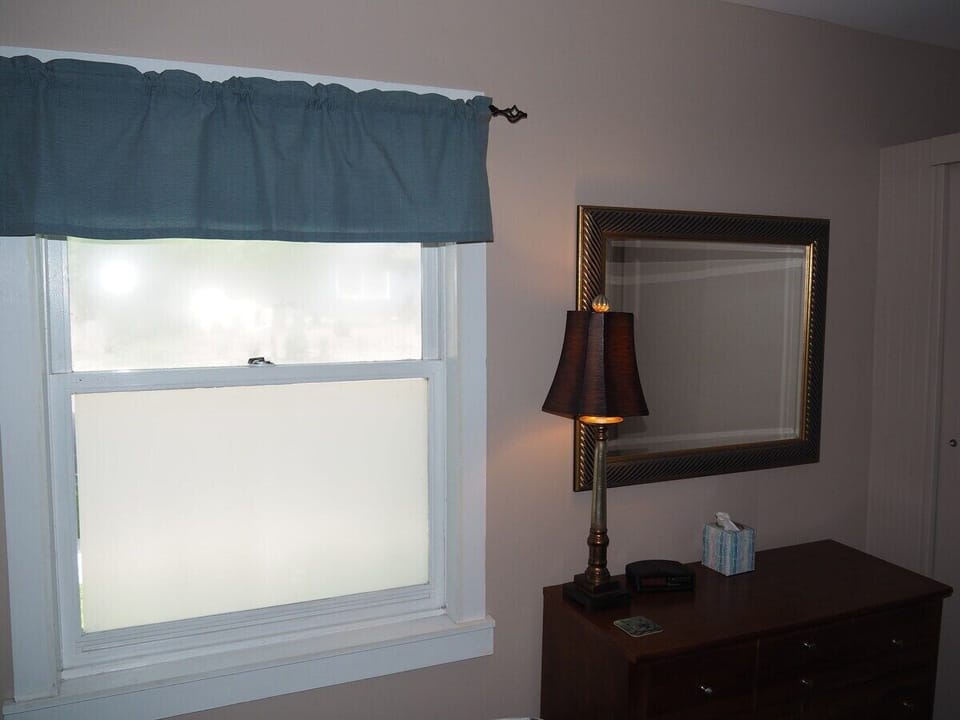 BEDROOM #1:  Features a queen-size bed, nightstand, lamp, dresser, mirror, closet, and television.