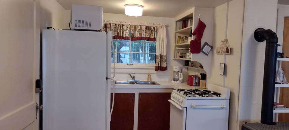 KITCHEN:  The cabin has a modern and fully-functional kitchen with a refrigerator, sink, gas range, and a good collection of cooking and dining utensils.