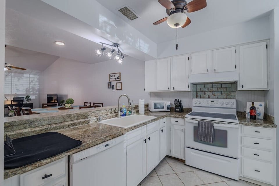 Kitchen overviewing the dining room and living room. Fully stocked with pots, pans, blender, toas