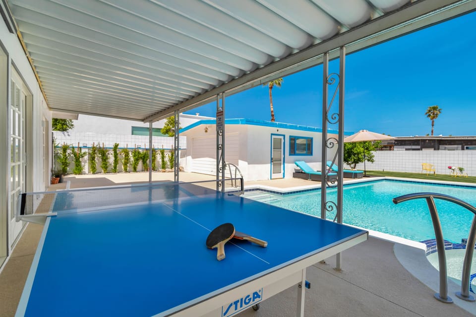 Large outdoor space with pool, loungers, and plenty of activity area
