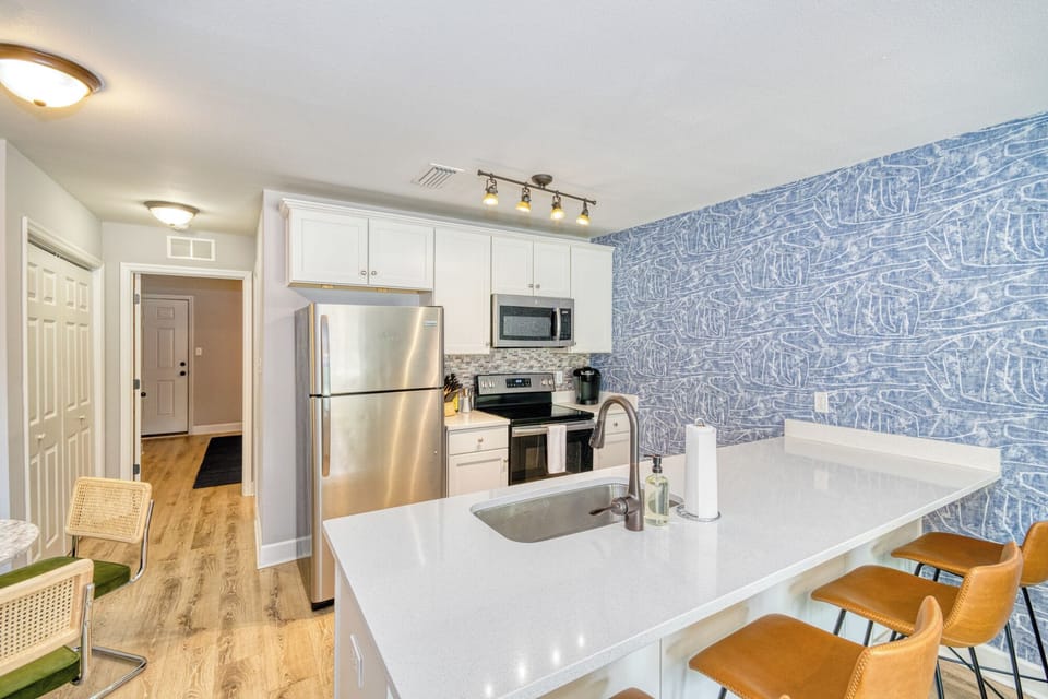 Whole view of the kitchen showcasing island kitchen with bar seating