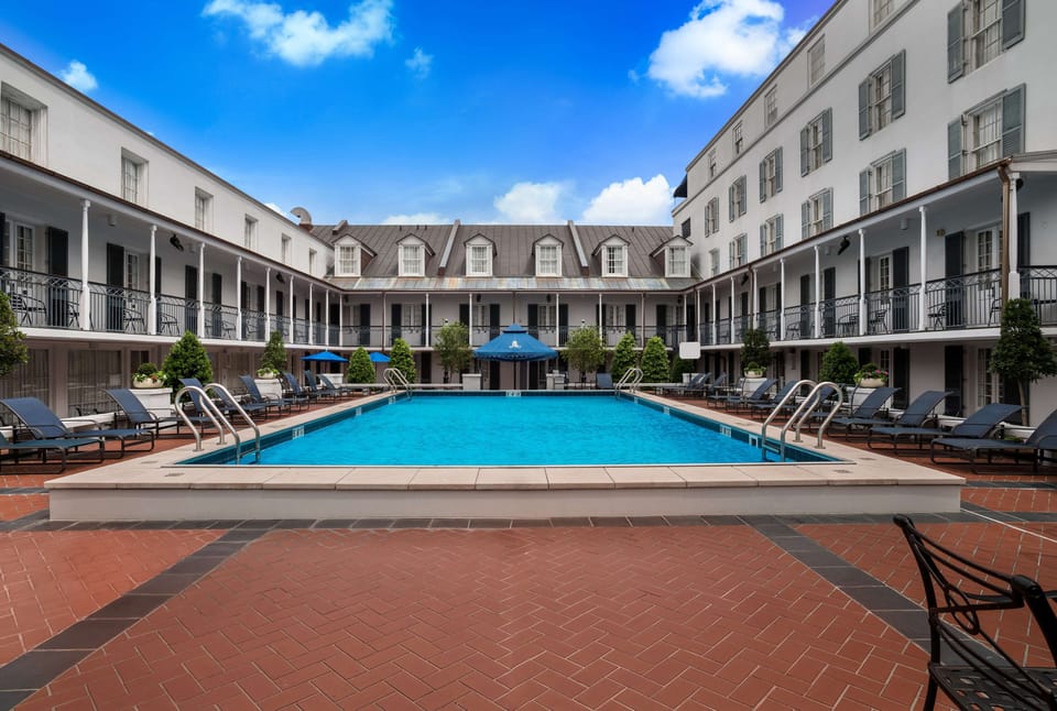 Dive into a sunlit courtyard pool surrounded by loungers.