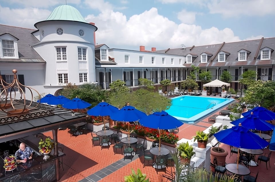 Linger poolside beneath bright umbrellas in the airy courtyard.