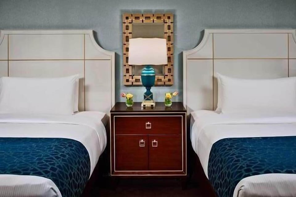 Drift off in serene symmetry with plush pillows and lighting.