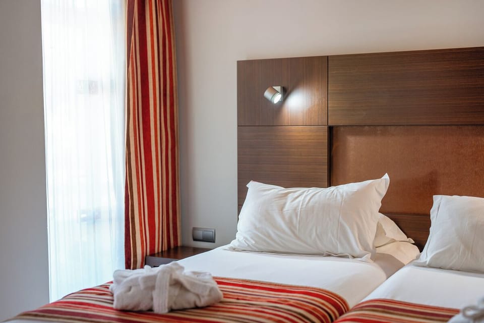 Relax into spotless linens and soft light by the window.