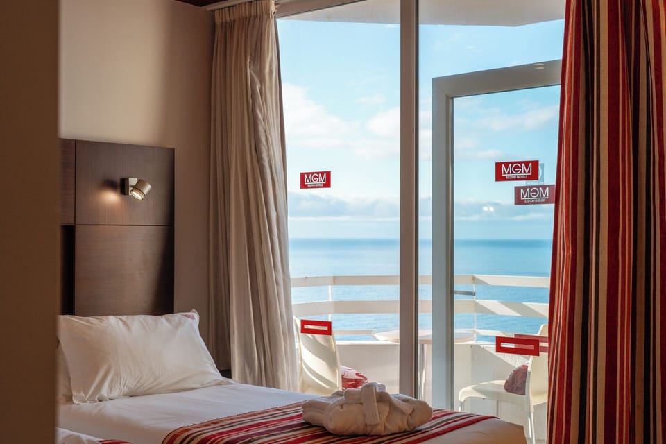 Breathe in salty air from bed with balcony just steps away.