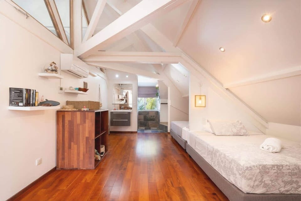 Loft-style bedroom with hardwood flooring.