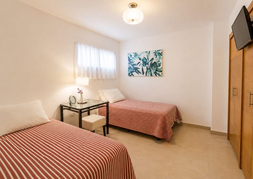 Second room with two twin beds, tv and closet. Second bathroom on the hallway.