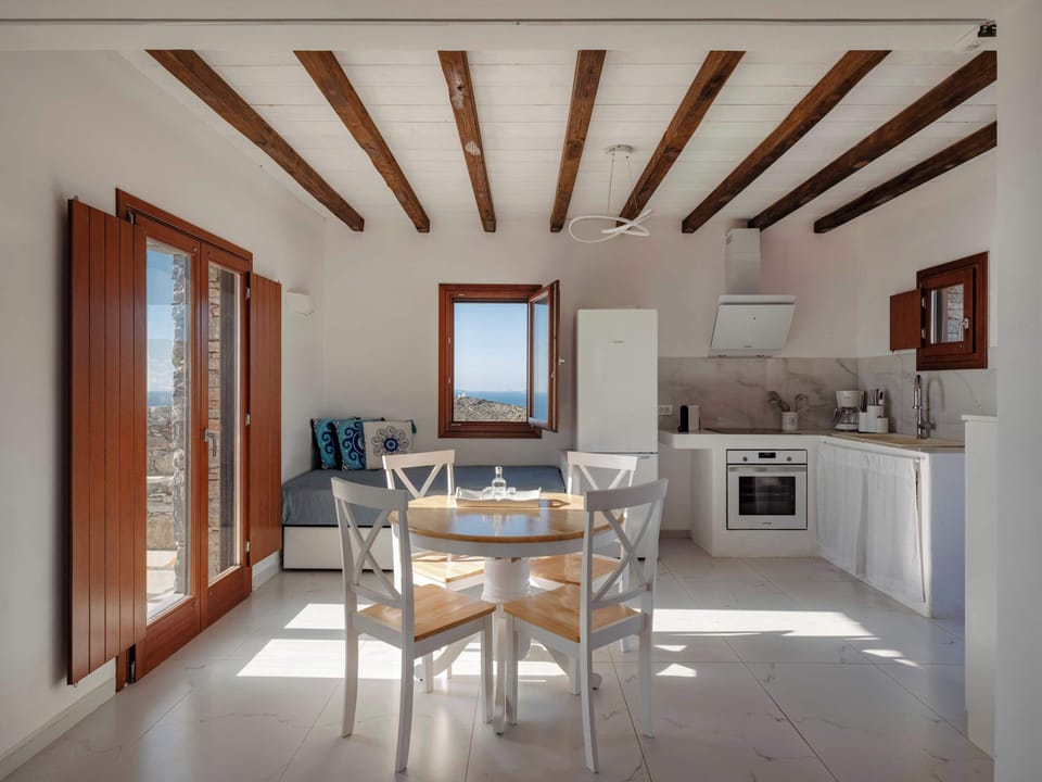 Spacious open-plan living area with exposed wooden beams.