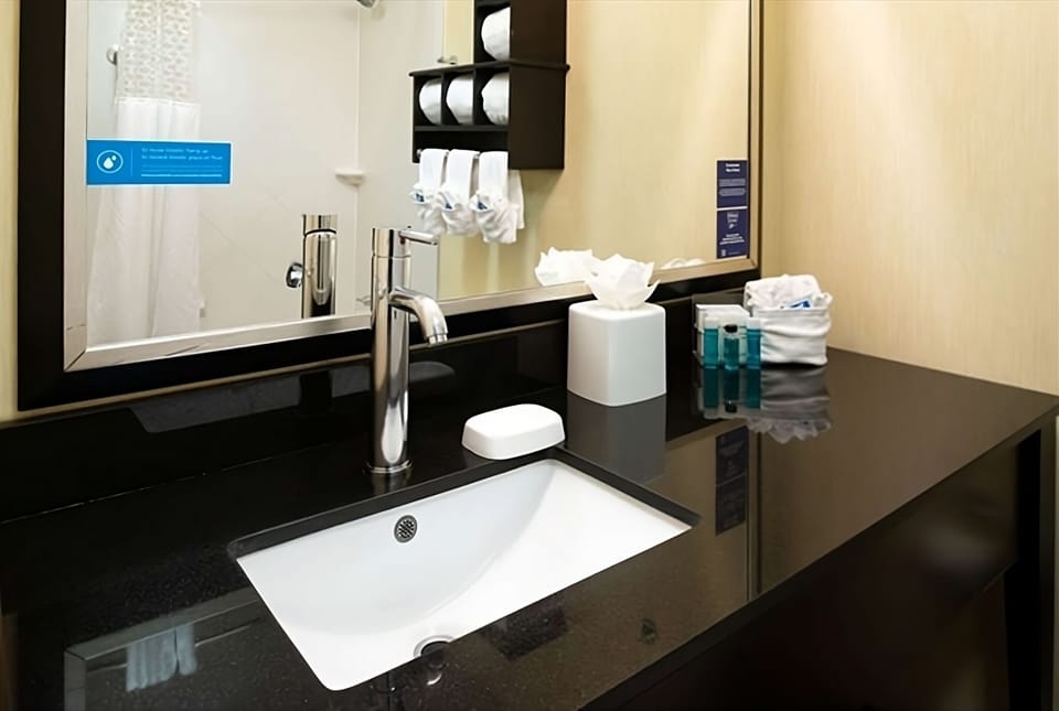 Refresh at a sleek vanity with bright lighting and essentials.