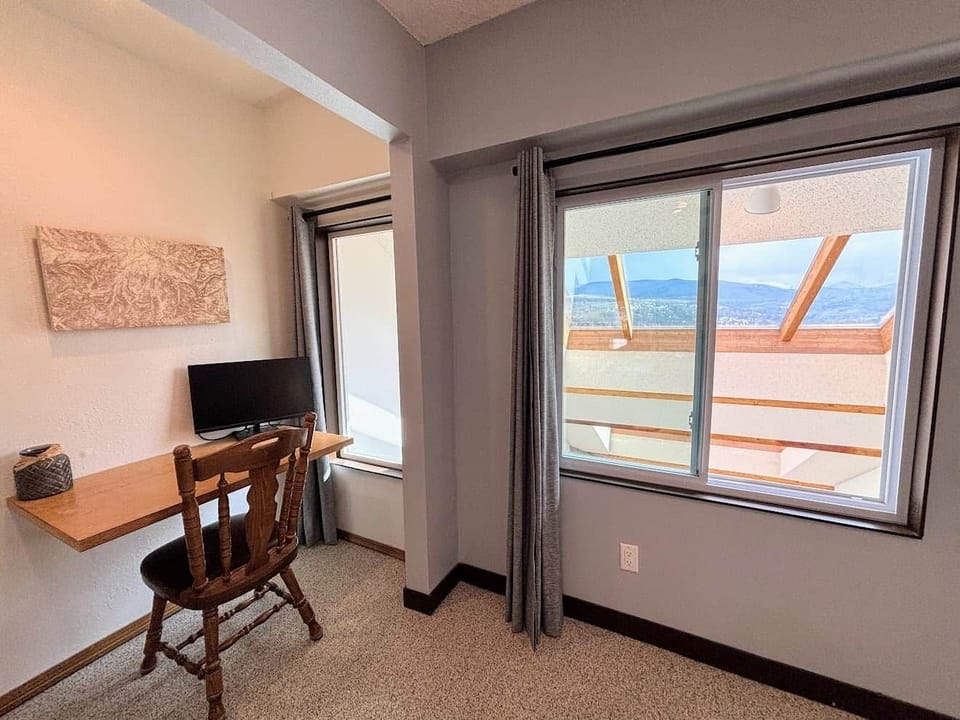 The master bedroom includes a desk, chair, and computer monitor for your work-from-home needs.