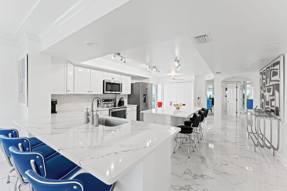 Luxurious all-white kitchen with high-end finishes and a spacious island.