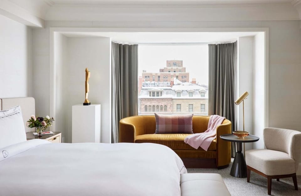 Wake up to skyline views from a plush, sunlit bed.