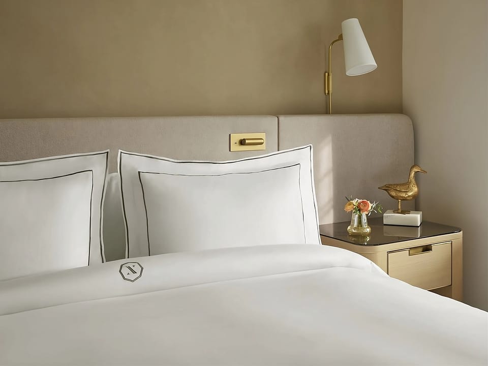 Drift off comfortably with serene decor and a quiet bedside glow.