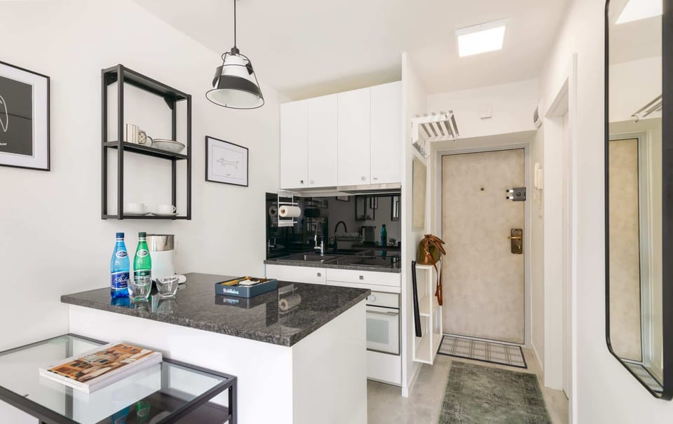 A functional kitchen with sleek black countertops, white cabinetry, and modern appliances for convenience.

