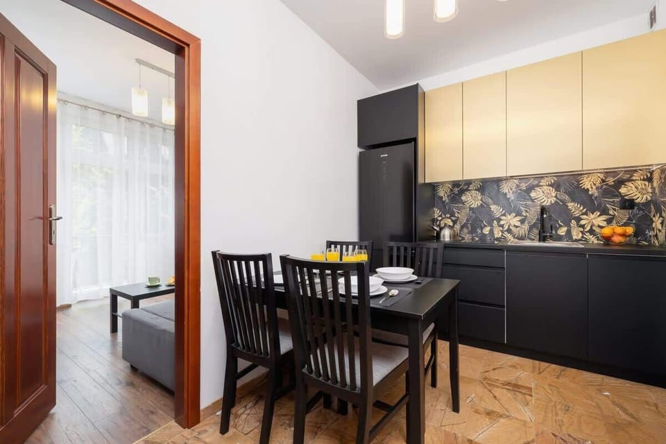 The dining area adjacent to the modern kitchen, featuring a table set for guests.
