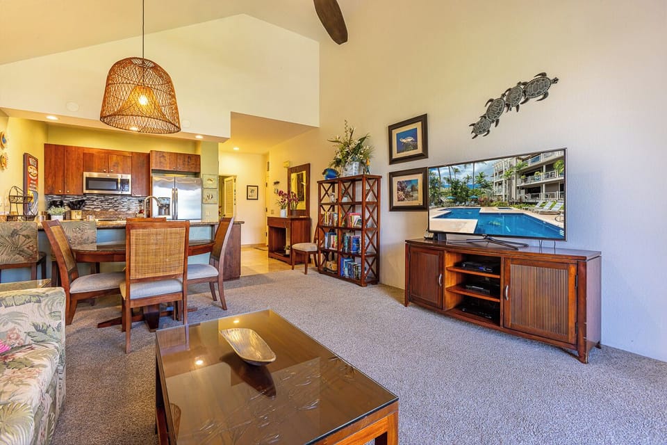 Sink into island life in your open-plan living space, where vaulted ceilings and tropical decor invite you to relax after sun-soaked days by the pool.