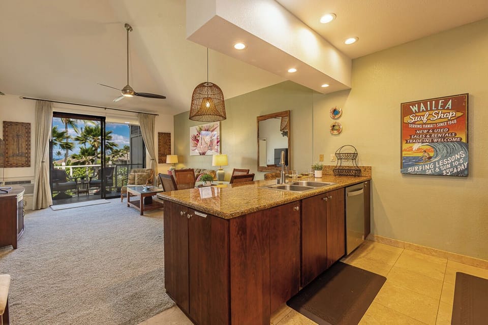 Your island kitchen flows into the living area, where tropical palms sway beyond the balcony and warm Hawaiian light fills every corner with island charm.