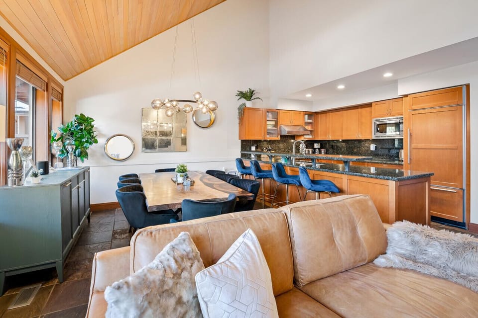 View of the dining room + kitchen showcasing the high vaulted ceiling