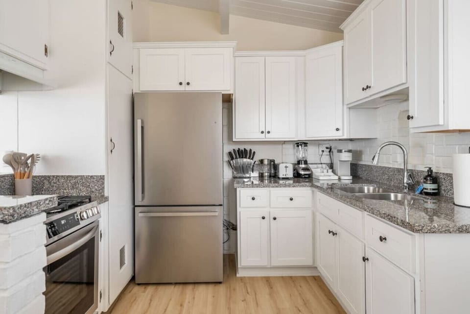Kitchen essentials: bar stool, microwave, Keurig coffee maker, refrigerator, 4-burner stove, oven, basic dining and cooking utensils, trash can.