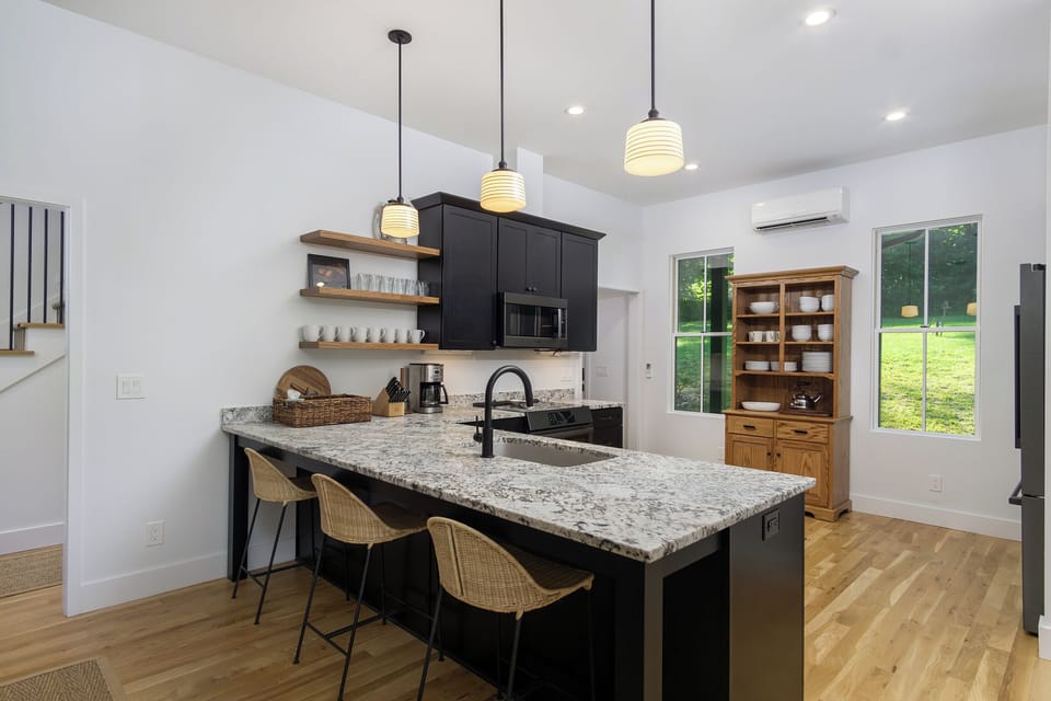 Sleek kitchen with bar seating for 3, a dishwasher, coffee grinder & 2 types of coffeemakers (French Press & Standard Drip).