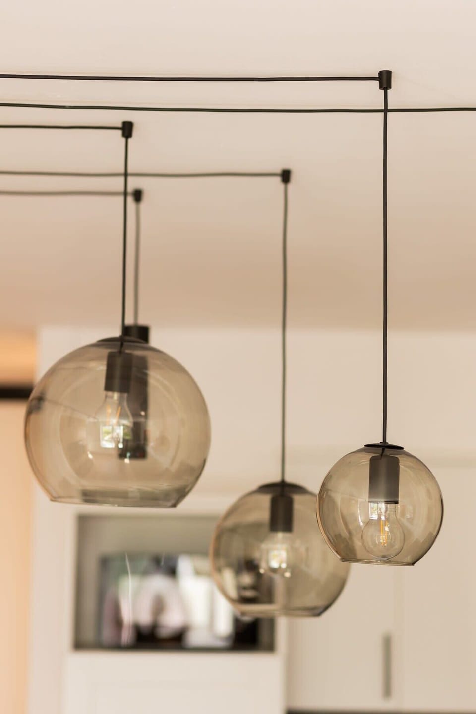 A close-up of modern pendant lights hanging above the dining area, adding an elegant touch.
