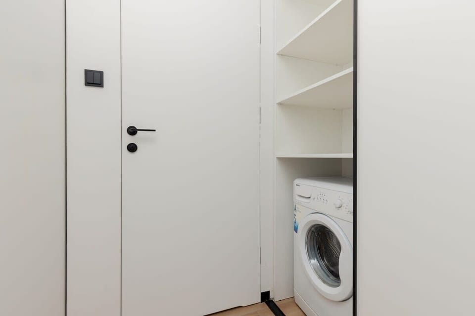 A utility area featuring a built-in washing machine and ample storage, blending functionality with design.
