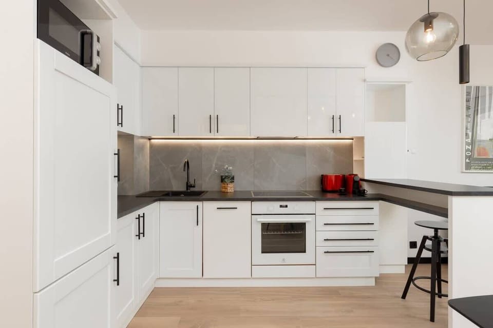 A closer look at the kitchen with modern appliances, red accents, and a clean design.

