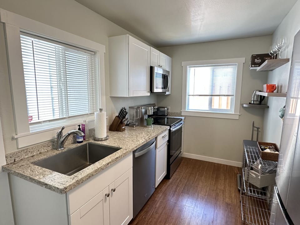 Kitchen windows lookout to fenced backyard and beautiful park. 