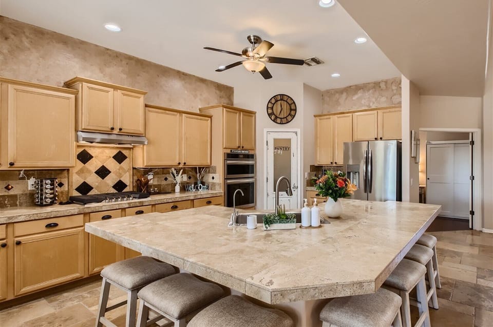 Gourmet kitchen with gas cooktop and stainless steel appliances. Island seats 8.