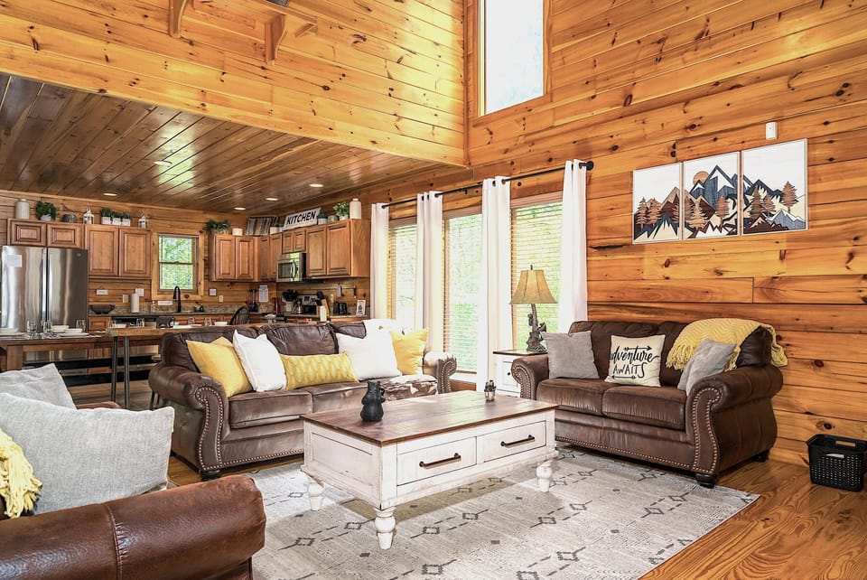 Spacious log cabin living room with cozy leather seating and rustic charm